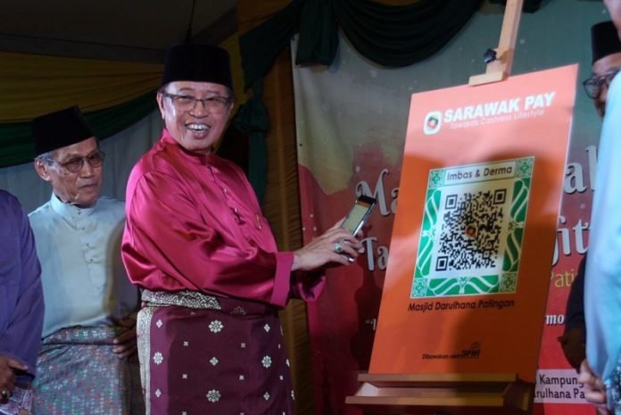 Abang Johari trying out Darul Hana Patingan Mosque’s Sarawak Pay facility by scanning the QR code with his smartphone.